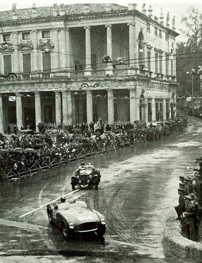 Mille Miglia Moment - Piero Taruffi;s Ferrari overtaking a Delahaye in pouring rain in front of the crowd at Vicenza