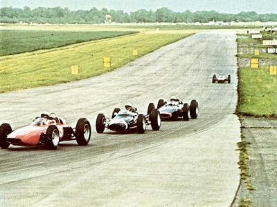 A group of mid 1960's F1 cars come off Hangar straight into Stowe