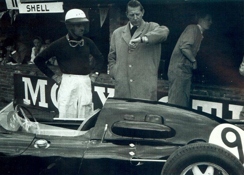 Rob Walker checks how much practice time is left while his driver Maurice Trintignant looks on